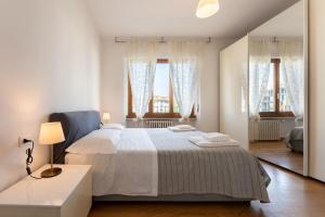 um quarto branco com uma cama grande e 2 janelas em Belfiore2 1 bedroom apt by the railways station em Florença