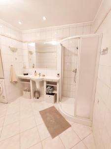 a white bathroom with a shower and a sink at Štýlový Apartmán Andrea blízko Snowlandu Valča in Stará Turá