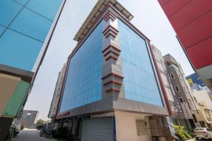 un grand bâtiment avec des fenêtres à miroir dans une rue dans l'établissement Gateway Premium Inn, à Bangalore