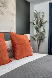 a bed with orange and white pillows on it at Sauceda Cottage at Wrenwood Ranch, King Bed in Johnson City