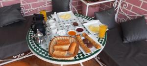 a breakfast tray with bread and eggs and drinks on a bed at Hotel salem leksor in Marrakesh
