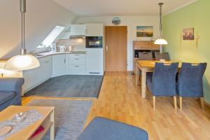 a kitchen and living room with a table and chairs at Ferienwohnung Mareike in Dornum