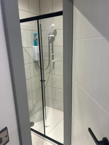 a shower in a bathroom with a glass door at Modern Double Room - Near Greenwich Park - The O2 Arena - Nearby Transport Links to Central London - New Cross Station - Lewisham SE14 in London