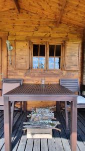 a wooden cabin with a wooden table and chairs at wooden cabin in nature in Troche