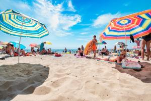 un grupo de personas en una playa con sombrillas en Premier Fort Sands Resort - Full Board en Sunny Beach