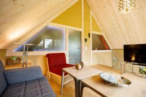 ein Wohnzimmer mit einem Sofa, einem Tisch und einem TV in der Unterkunft Rotes Haus in Monschau