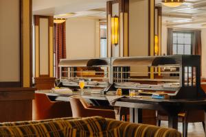 Oranje Hotel Leeuwarden في ليوواردن: غرفة طعام مع طاولة طويلة مع كراسي