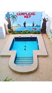 uma piscina com um mural na parede em Complexe M27 em Sali Nianiaral