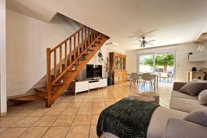 a living room with a staircase and a couch at Vias Plage - Villa avec piscine privé in Vias