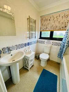 a bathroom with a white sink and a toilet at Vintage style Lodge In Windsor! Hot Tub! Sleeps 20 in Bray