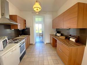 a kitchen with wooden cabinets and a stove top oven at RÉF 407 - LARMOR PLAGE Maison de famille pleine vue mer in Larmor-Plage +15 photos