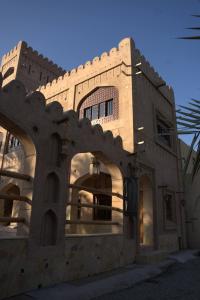 a building with an archway in front of it at Aldar Inn in Nizwa