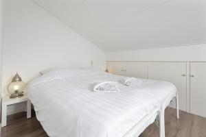 - un lit blanc avec 2 serviettes dans une chambre dans l'établissement De Entos, à Zandvoort