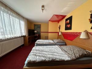 a room with two beds and a television in it at Gasthaus zur Schwarzen Olive Zimmer 12 in Erlangen