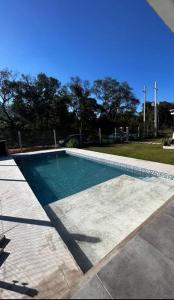 a swimming pool with blue water in a yard at Casa Quincho con Piscina in Luque