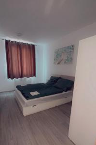 a small bedroom with a bed with a window at Kőris Pool Apartments in Budapest