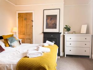 1 dormitorio con 1 cama con toallas en Riverside Lodge - Quaint Victorian Home By The River en York