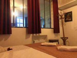 a bedroom with a bed with red curtains at Appartement pour 2 personnes à 50 mètres du port in Paimpol