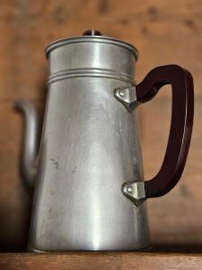 a metal pot with a handle on a table at Le Porteau Enchanteur in Sarzay