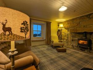 a living room with a fireplace and a stone wall at Historic character cottage in central Dornoch in Dornoch