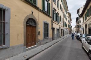 osoba idąca ulicą obok budynku w obiekcie F5 -Santa Croce one bedroom flat 2 to 4 guests we Florencji