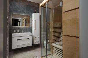 uma casa de banho com um lavatório e uma cabina de duche em vidro. em AIRSTAY PRAGUE apartment Vinohrady em Praga