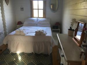 a bedroom with a bed with two towels on it at Trevenna Cabin in St Austell