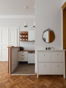 cocina con armarios blancos y espejo en AIRSTAY PRAGUE apartment Vinohrady, en Praga