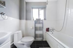 a bathroom with a toilet and a sink and a tub at Beautiful 2 Bedroom house, Wendover Free Parking in Wendover