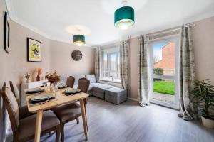 a living room with a dining table and a living room with a couch at Beautiful 2 Bedroom house, Wendover Free Parking in Wendover