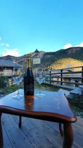a bottle of wine and two wine glasses on a table at A REALDO - Casa Paolina in Triora