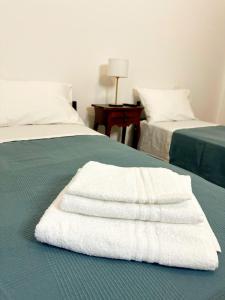 2 asciugamani bianchi sono seduti su un letto di La Casa di Garibaldi a San Demetrio neʼ Vestini