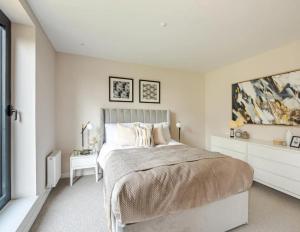 a white bedroom with a large bed and a table at Kings Mews Elegance: City Sparrow's Premier 2-Bedroom Residences in London