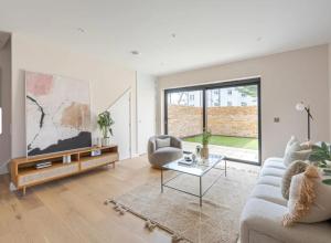 a living room with a couch and a table at Kings Mews Elegance: City Sparrow's Premier 2-Bedroom Residences in London