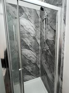 a shower with a stone wall in a bathroom at Snugly Studio Flat near Talbot Pub in Birmingham