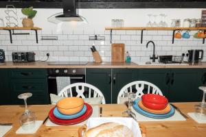 a kitchen with green cabinets and a wooden table with plates at Cottage On The Brook in Keswick