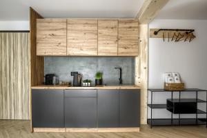 a kitchen with wooden cabinets and a counter top at Przystanek SUCHE in Poronin