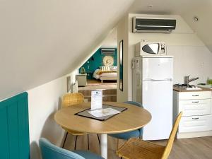 eine Küche und ein Esszimmer mit einem Tisch und einem Kühlschrank in der Unterkunft Gîte de la Croix in Villechétif
