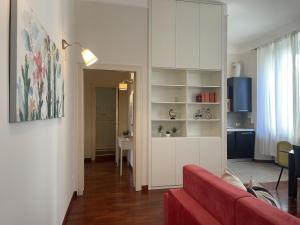 un soggiorno con divano rosso e tavolo di Umbria 60 Apartment a Milano