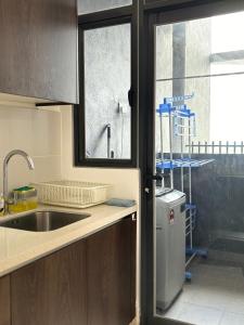 eine Küche mit einem Waschbecken und einem Fenster in der Unterkunft Two Bedroom Troika Kota Bharu by AGhome in Kota Bharu