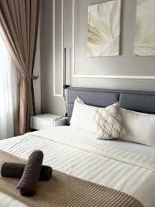 a bedroom with a bed with white sheets and pillows at Two Bedroom Troika Kota Bharu by AGhome in Kota Bharu