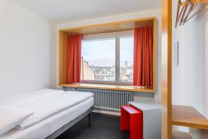 a bedroom with a bed and a window with a view at Hotel Marta in Zurich