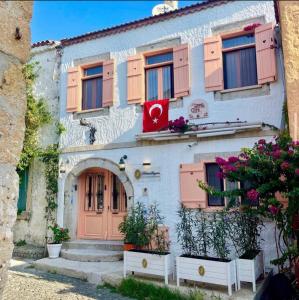 ein Gebäude mit rosa Türen und Blumen darauf in der Unterkunft Krem Hotel in Alacati