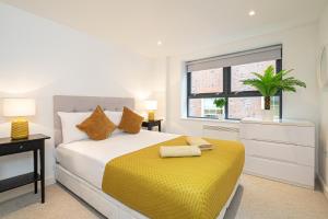 Stay Fleet Street في لندن: غرفة نوم بسرير وبطانية صفراء