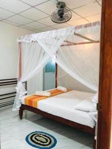 1 cama con dosel en una habitación en Tashil Hotel & Restaurant en Tissamaharama