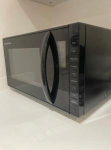 un four micro-ondes avec une porte noire sur un comptoir dans l'établissement The Studio, à Appledram