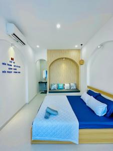 1 dormitorio con 1 cama grande con manta azul en VILLA BIỂN XANH 3 - View Biển Đảo Phú Quý, en Cu Lao Thu
