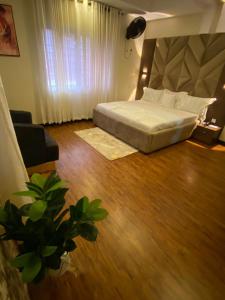 um quarto de hotel com uma cama e um sofá e aarijuanaarijuana em KAFT2 HOTELS em Ijebu Ode