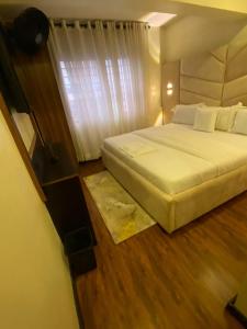 Un dormitorio con una cama grande y una ventana en KAFT2 HOTELS, en Ijebu Ode