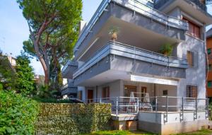 een appartementencomplex met een balkon en palmbomen bij grande appartamento zona viale ceccarini con giardino in Riccione